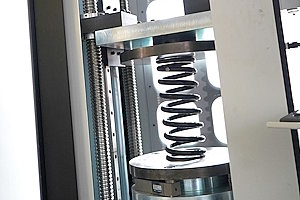 A spring under test in an IST load-testing machine